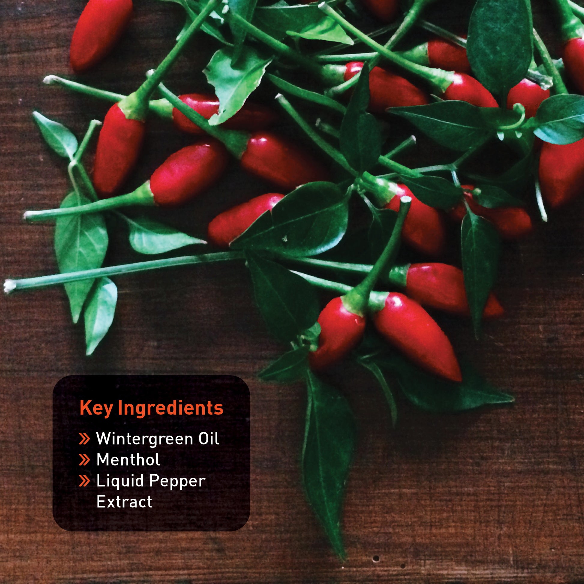 Red peppers with green leaves on a wooden surface, labeled with key ingredients of Wintergreen Warmup Ultra